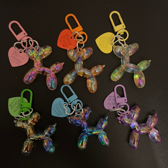 Colorful keychains shaped like balloon animals on a black surface